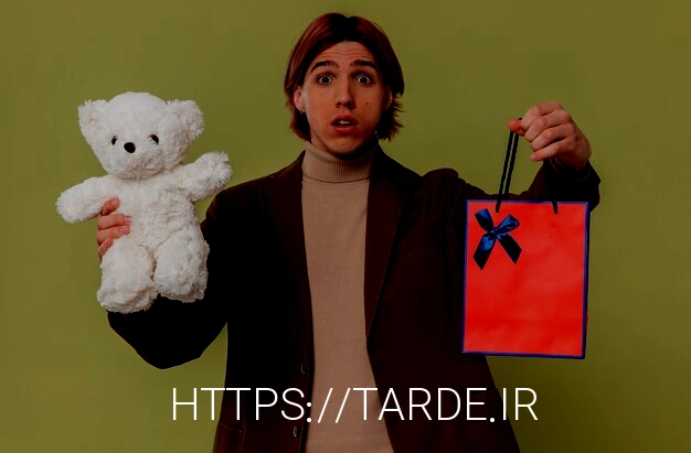 Free photo anxious young handsome man holding white teddy bear and gift bag